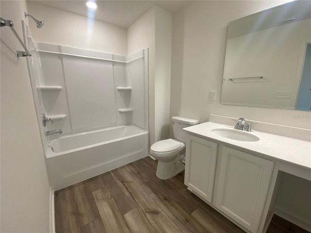 full bathroom with shower / tub combination, vanity, wood-type flooring, and toilet