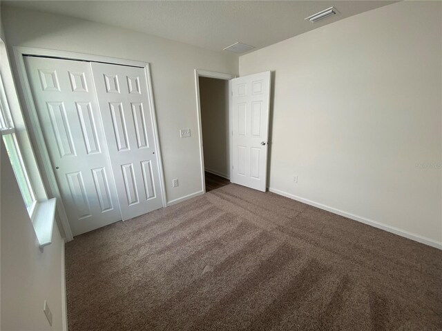 10 Windor Ter, Palm Coast, FL 32164 - unfurnished bedroom featuring dark carpet and a closet
