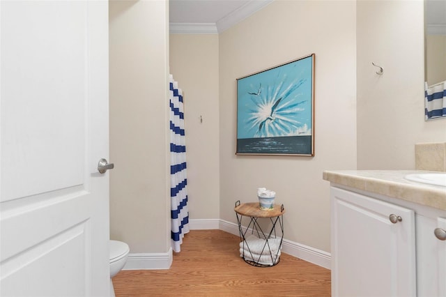 bathroom featuring vanity, toilet, ornamental molding, curtained shower, and wood-type flooring