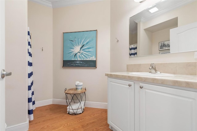 bathroom with vanity, wood-type flooring, and crown molding