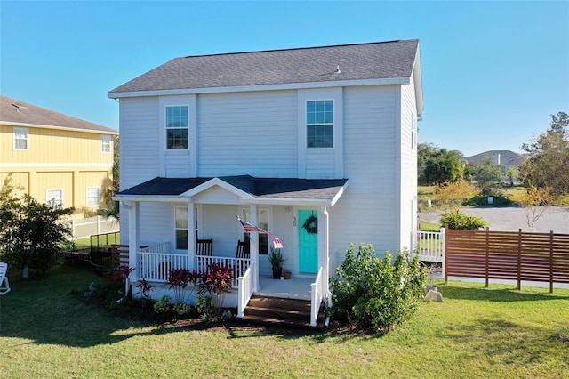 front facade with covered porch and a front yard