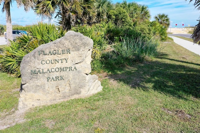 community / neighborhood sign featuring a yard