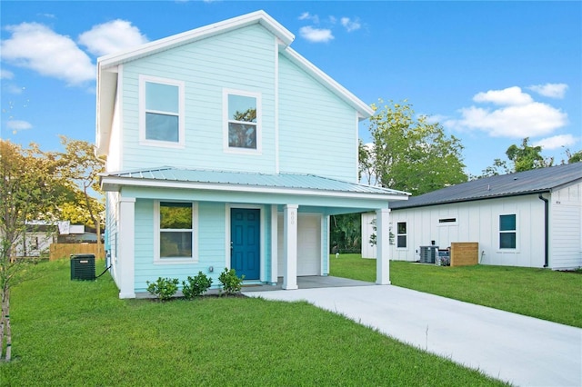 view of front facade with a garage, covered porch, central air condition unit, and a front yard