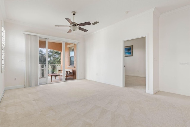 unfurnished room with ceiling fan, light colored carpet, and crown molding