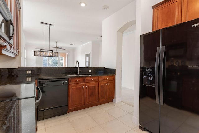 kitchen with ceiling fan, sink, black appliances, pendant lighting, and dark stone countertops