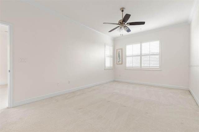 empty room with ceiling fan, light colored carpet, and ornamental molding