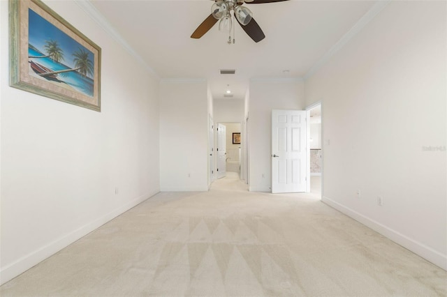 carpeted empty room featuring ceiling fan and crown molding