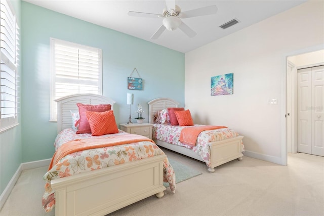 bedroom featuring light carpet, a closet, and ceiling fan