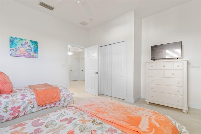 bedroom featuring light carpet, a closet, and ceiling fan