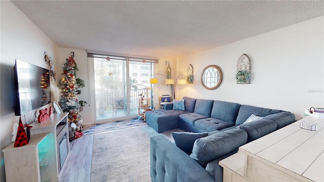 living room with hardwood / wood-style floors, expansive windows, and a textured ceiling