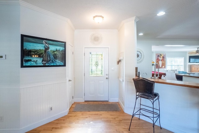 entryway featuring crown molding, sink, ceiling fan, and light wood-type flooring