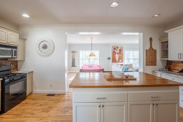 kitchen with black gas range, ornamental molding, pool table, a kitchen island, and butcher block counters