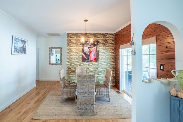 dining space featuring light hardwood / wood-style floors, an inviting chandelier, and crown molding