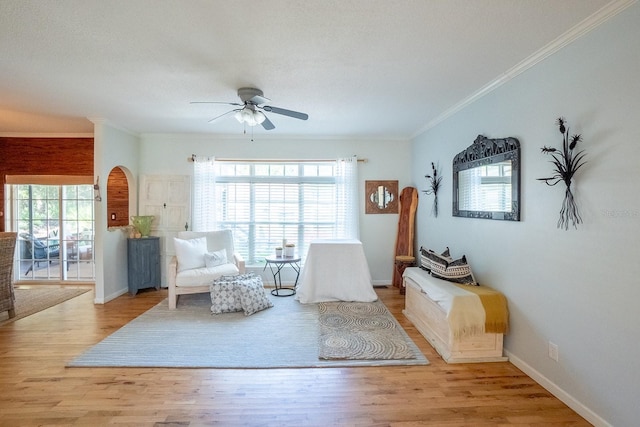 sitting room with light hardwood / wood-style floors, ceiling fan, and ornamental molding