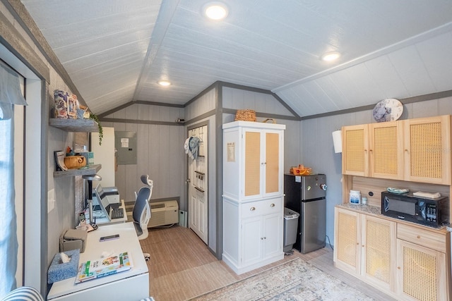 kitchen featuring stainless steel fridge, electric panel, lofted ceiling, and wood walls