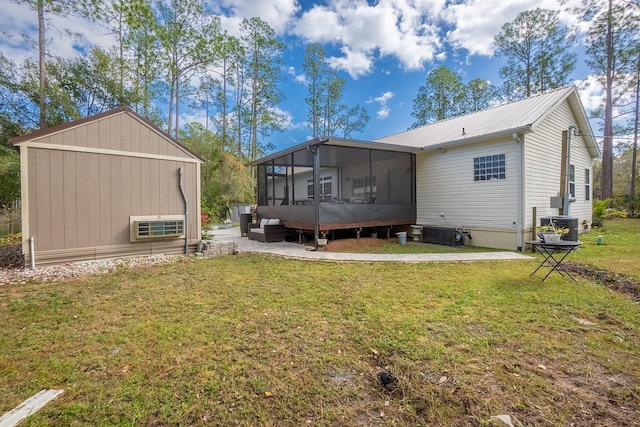 rear view of property with a lawn, a sunroom, and cooling unit