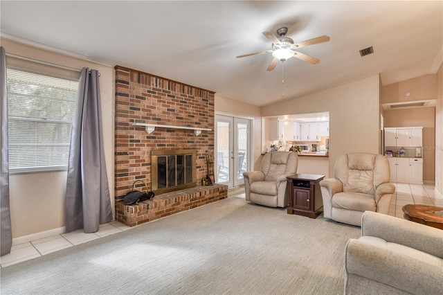 living room featuring ceiling fan, light tile patterned flooring, vaulted ceiling, and a brick fireplace