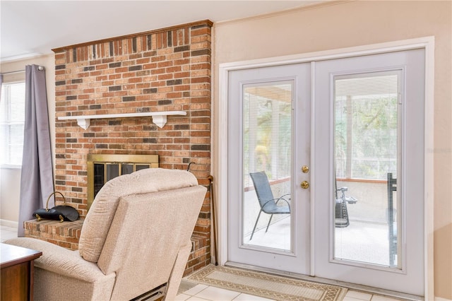 entryway featuring a fireplace, french doors, light tile patterned floors, and ornamental molding