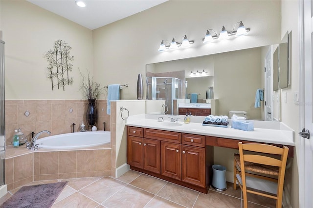 bathroom with a stall shower, tile patterned flooring, a garden tub, and vanity