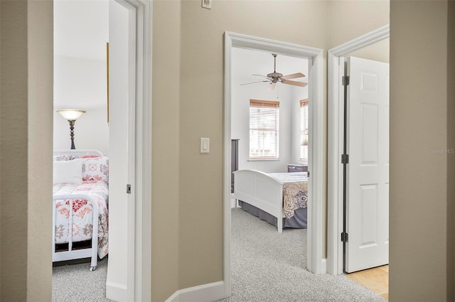 hallway featuring carpet and baseboards