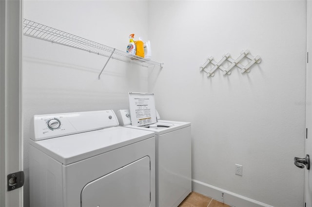 laundry room featuring washing machine and clothes dryer and light tile patterned floors