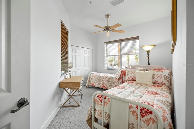 carpeted bedroom with a ceiling fan, visible vents, baseboards, and a closet