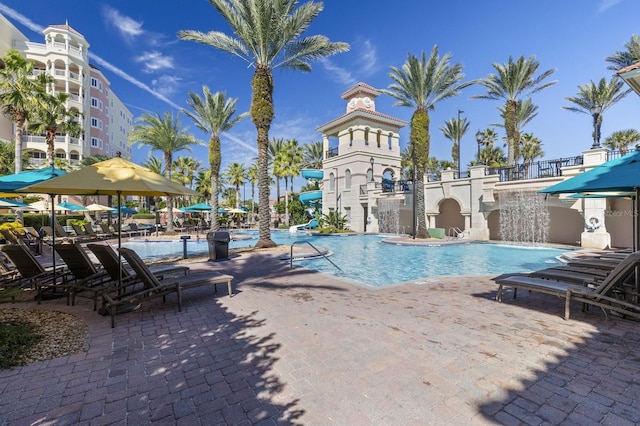 pool with a patio area and a water slide