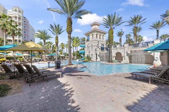 pool with a water slide and a patio