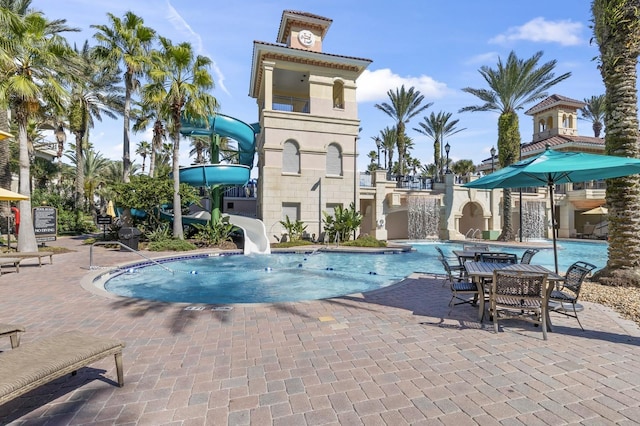 pool featuring a water slide and a patio