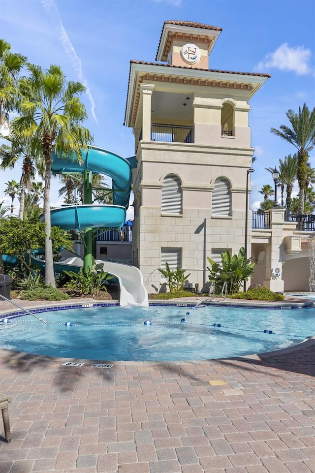 back of house with a balcony and a community pool