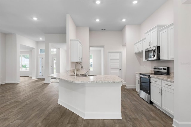 kitchen with a sink, appliances with stainless steel finishes, dark wood-style floors, and white cabinetry