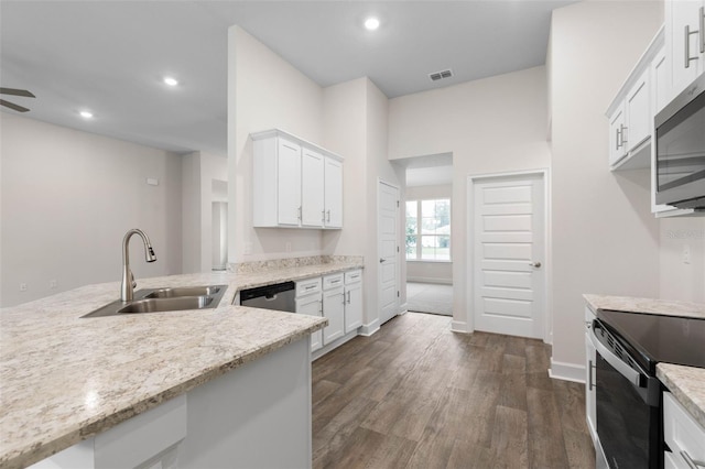 kitchen featuring dark wood finished floors, recessed lighting, stainless steel appliances, white cabinetry, and a sink