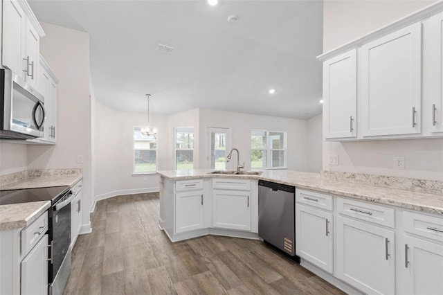 kitchen with a sink, dark wood finished floors, white cabinetry, stainless steel appliances, and a peninsula