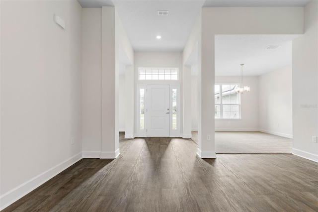 entryway with visible vents, baseboards, an inviting chandelier, and dark wood-style floors