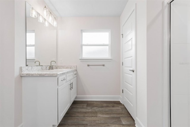 bathroom featuring vanity, baseboards, and wood finished floors