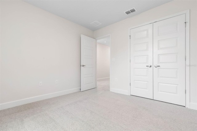 unfurnished bedroom featuring a closet, visible vents, carpet flooring, and baseboards