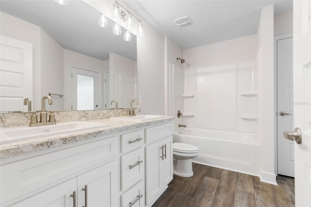 bathroom with shower / tub combination, toilet, wood finished floors, and a sink