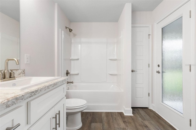 full bathroom featuring tub / shower combination, toilet, wood finished floors, and vanity