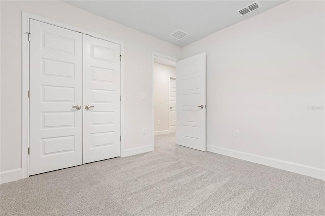 unfurnished bedroom featuring a closet, baseboards, visible vents, and carpet floors