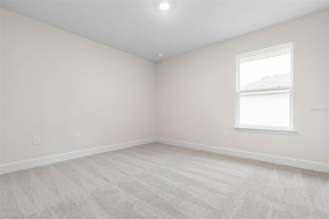 spare room featuring baseboards and carpet floors