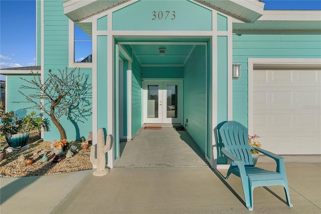 view of exterior entry with french doors and a garage