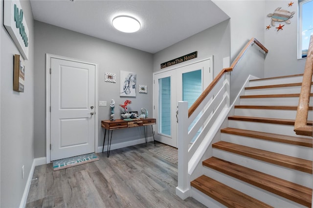 entrance foyer featuring light hardwood / wood-style floors, a textured ceiling, and french doors