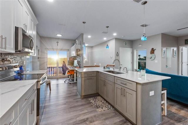 kitchen featuring tasteful backsplash, sink, hanging light fixtures, and appliances with stainless steel finishes