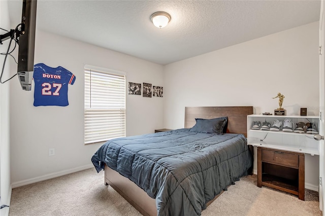 bedroom featuring light colored carpet and a textured ceiling