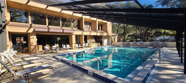 view of swimming pool with a patio and glass enclosure