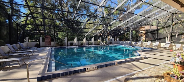 view of pool with glass enclosure and a patio