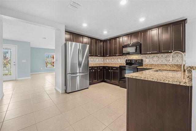 kitchen with backsplash, dark brown cabinetry, sink, and black appliances