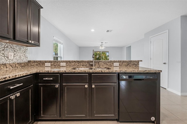 kitchen with light stone counters, ceiling fan, sink, black dishwasher, and light tile patterned flooring