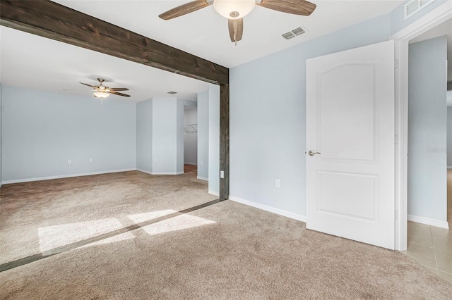 spare room with beam ceiling, light carpet, and ceiling fan