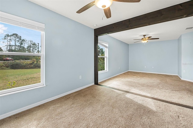 carpeted empty room featuring beam ceiling and ceiling fan